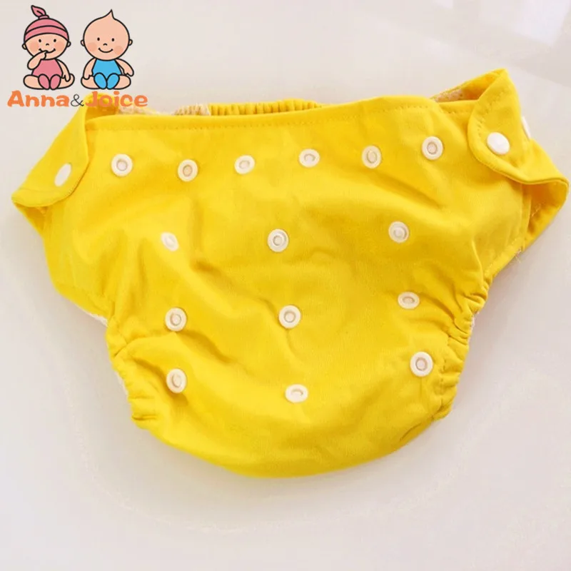 Un pañal amarillo con lunares blancos. Parece ser un pañal para bebé, con elástico alrededor de la cintura y las piernas para un ajuste cómodo.