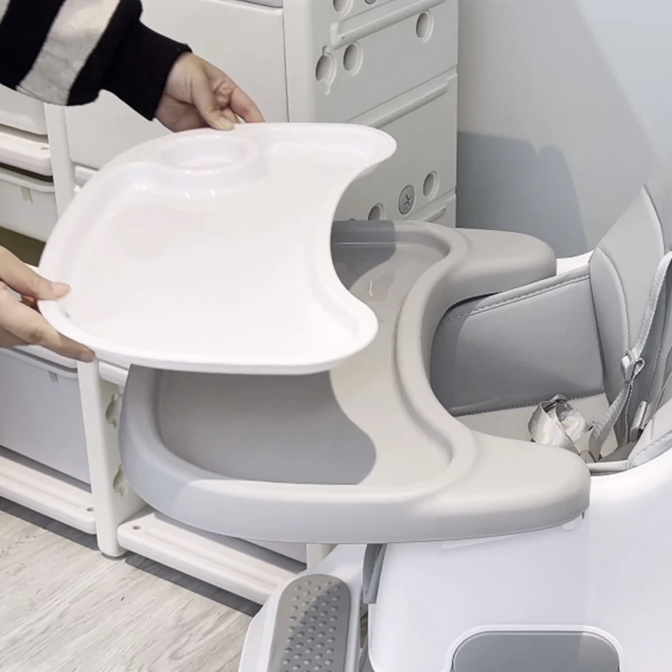 Una persona que sostiene un plato blanco en el asiento del bebé