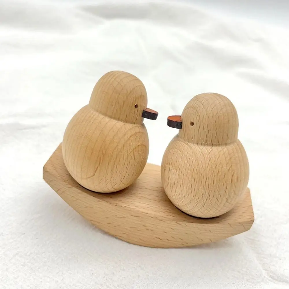 Dos pájaros de madera sentados en un bote