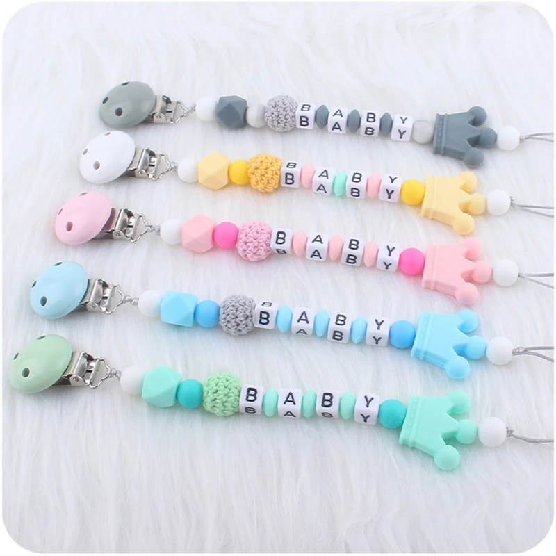 Una fila de chupetes para bebés con diferentes colores y letras