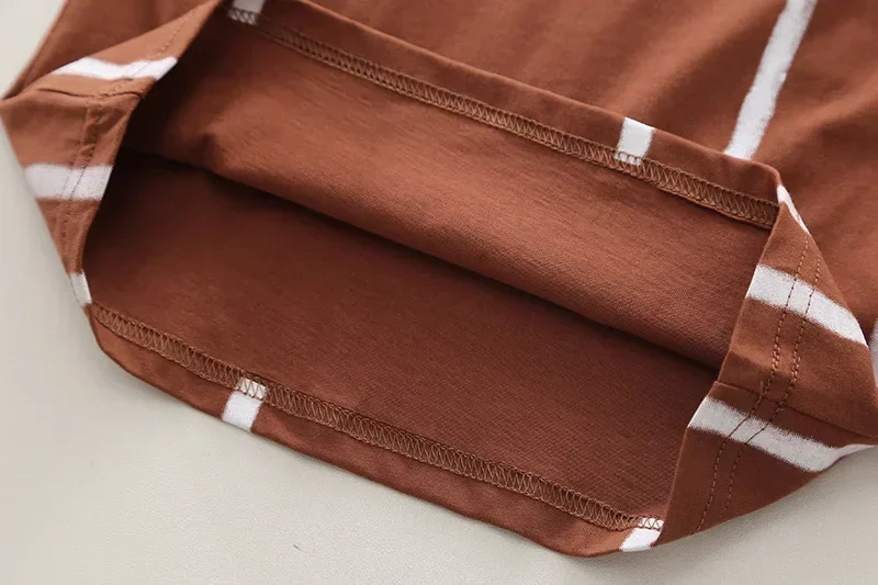 Una camisa marrón con bolsillo y rayas blancas