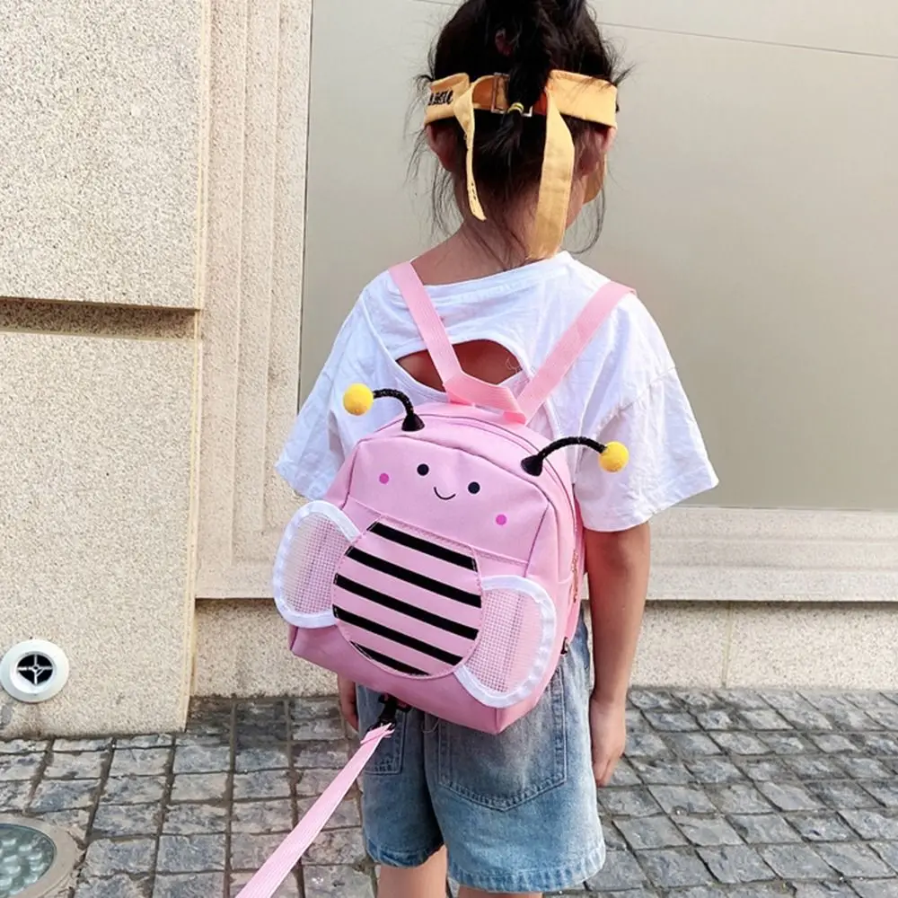 Una chica con una mochila rosa con una abeja