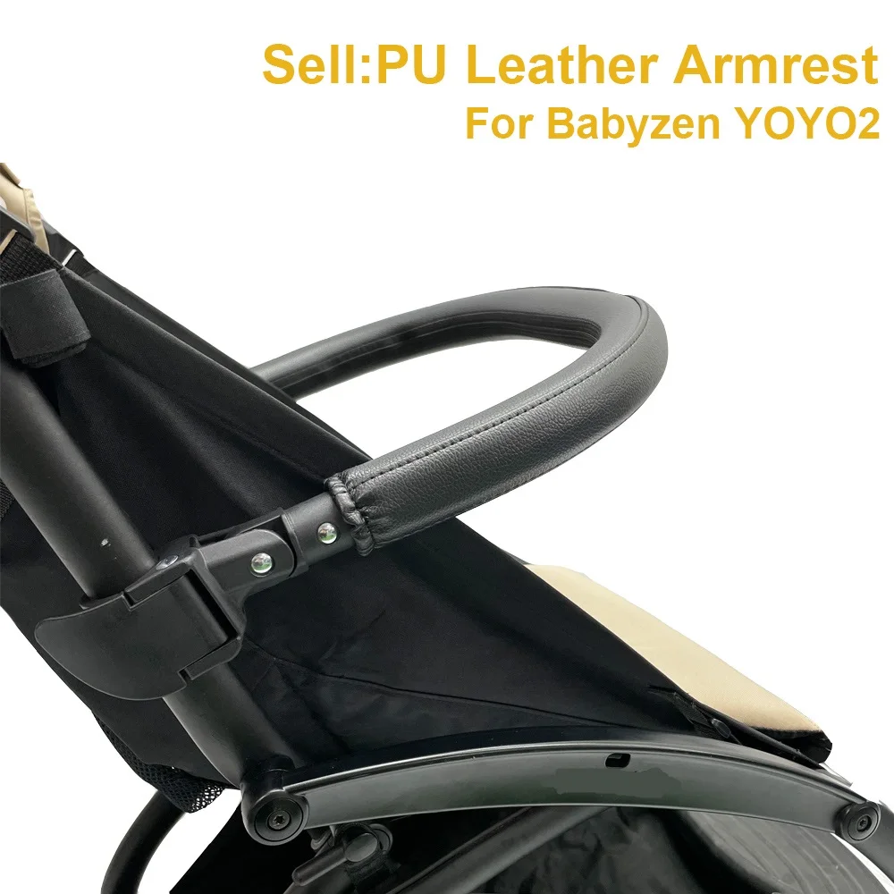 Un reposabrazos de piel sintética diseñado para una silla de paseo Babyzen YOYO2. El reposabrazos es negro y parece ser un recambio o accesorio del cochecito, aportando comodidad y apoyo adicional al usuario.
