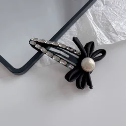 Clip de pelo con lazo negro y perlas para niña