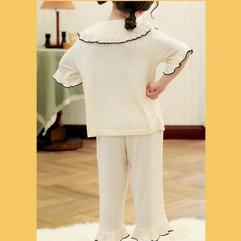 Una niña con una camisa blanca y pantalones