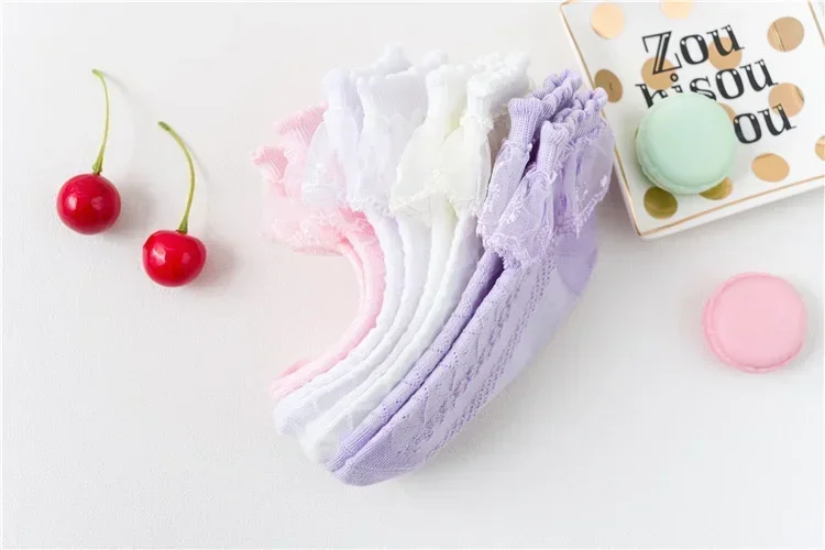 Una mesa blanca con un artículo de encaje rosa y morado
