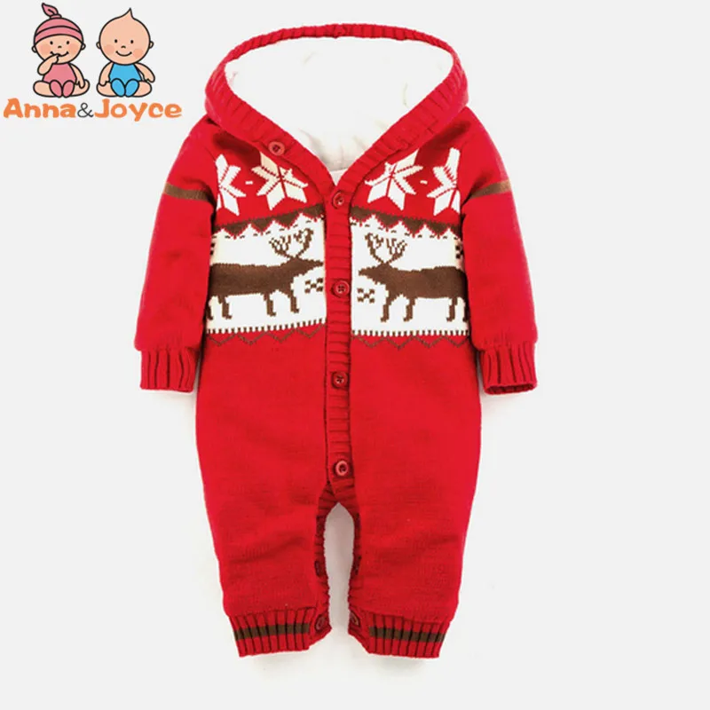 Un mono rojo con un estampado festivo. El patrón incluye un reno y lo que parecen ser copos de nieve, lo que sugiere un tema navideño. El mono tiene capucha, mangas largas y cierre de botón a presión. Parece que está diseñado para un bebé o un niño pequeño.