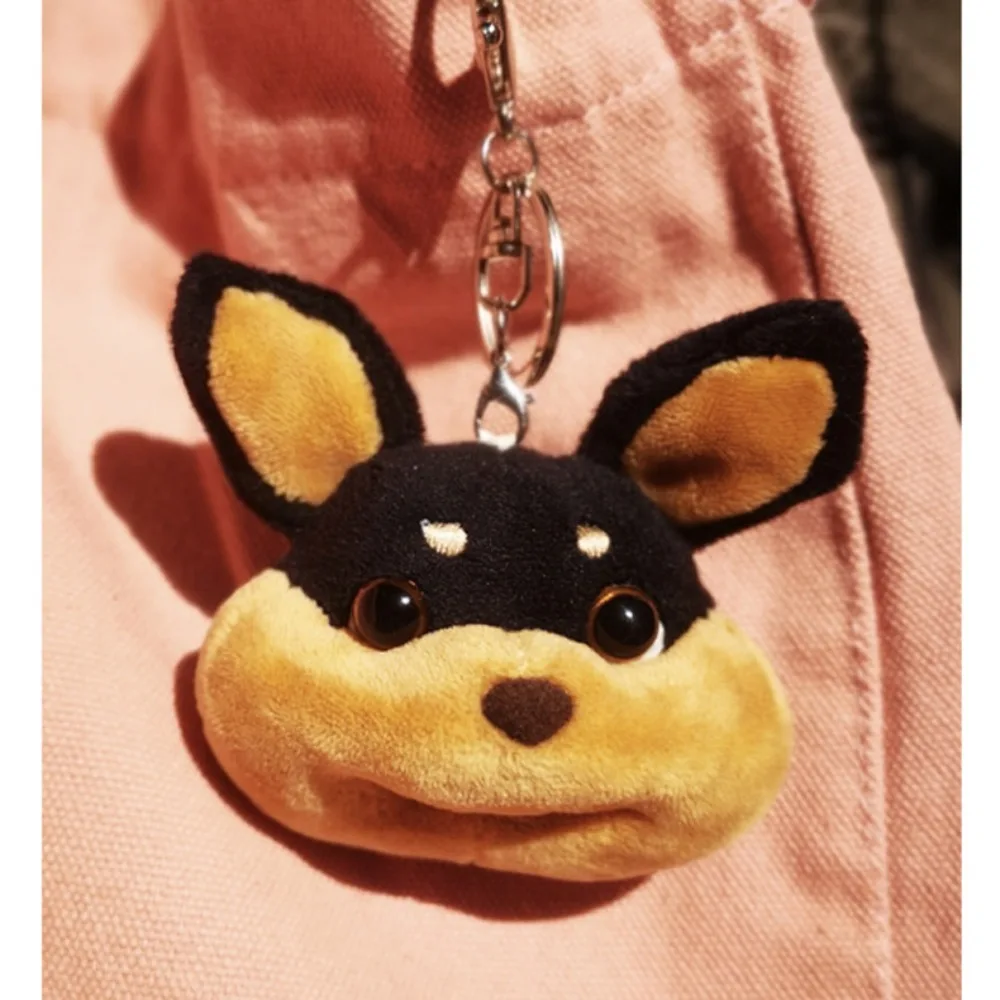 Un llavero de animales de peluche con cara de perro