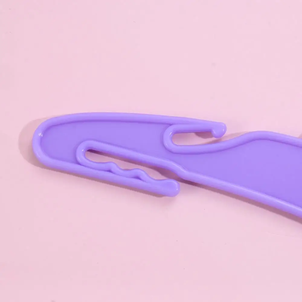 Un portapapeles morado con un clip en