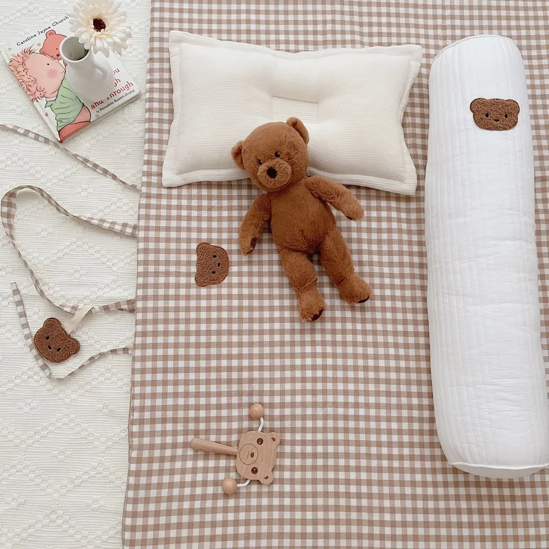 Una cama con un oso de peluche y una almohada