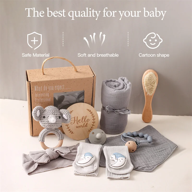 Una caja de regalo para bebés con una toalla de mono de juguete y otros artículos para bebés