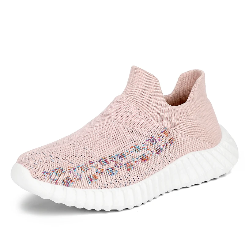 Un par de zapatillas. Parecen ser un estilo de zapatos sin cordones con una parte superior tejida y una suela gruesa y acolchada. La parte superior tiene un diseño estampado y el color del tejido de punto es un rosa suave con un efecto degradado que se desvanece al blanco hacia la suela.