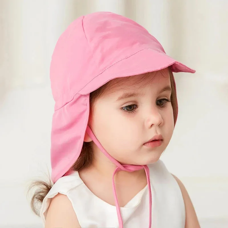 Una niña con un sombrero rosa y una camisa blanca