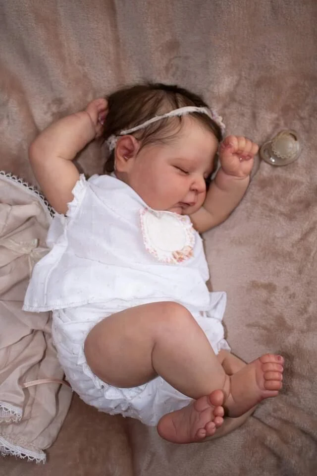 Un bebé con un vestido blanco y corona
