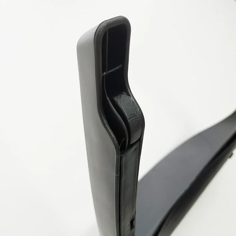 Un primer plano de un objeto negro que parece ser parte de un vehículo, posiblemente un automóvil. Parece un componente del interior del vehículo, como un panel de puerta o una parte del tablero.