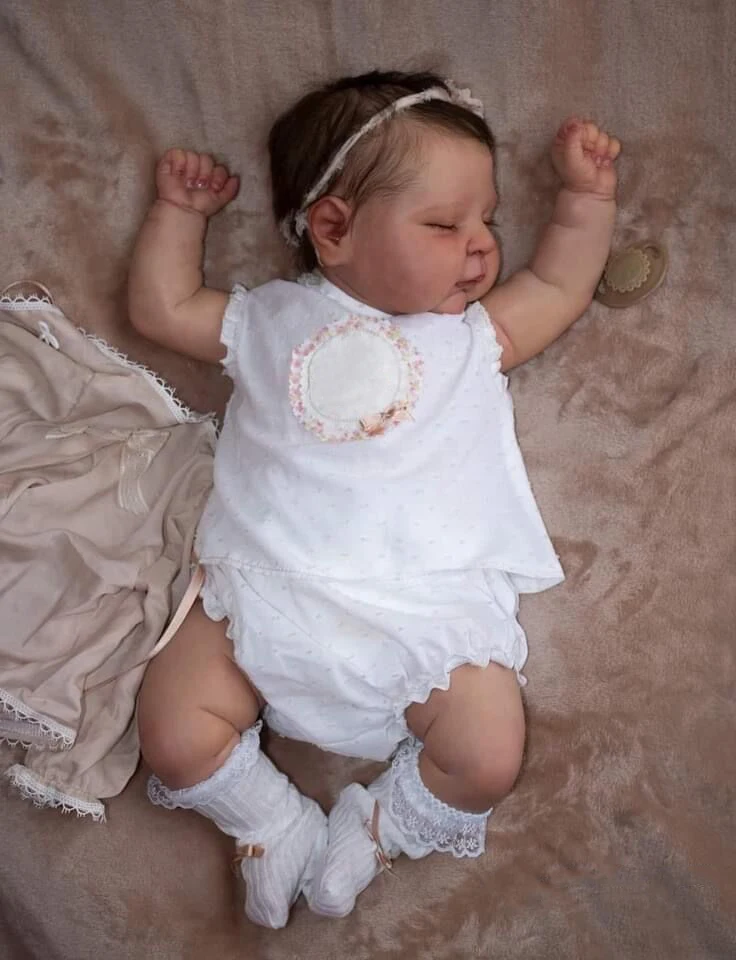 Un bebé con un vestido blanco y calcetines