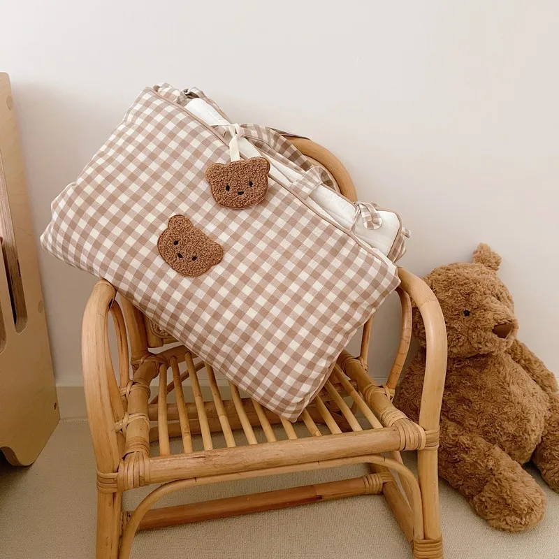 Una silla de madera marrón con una bolsa a cuadros blanca y marrón