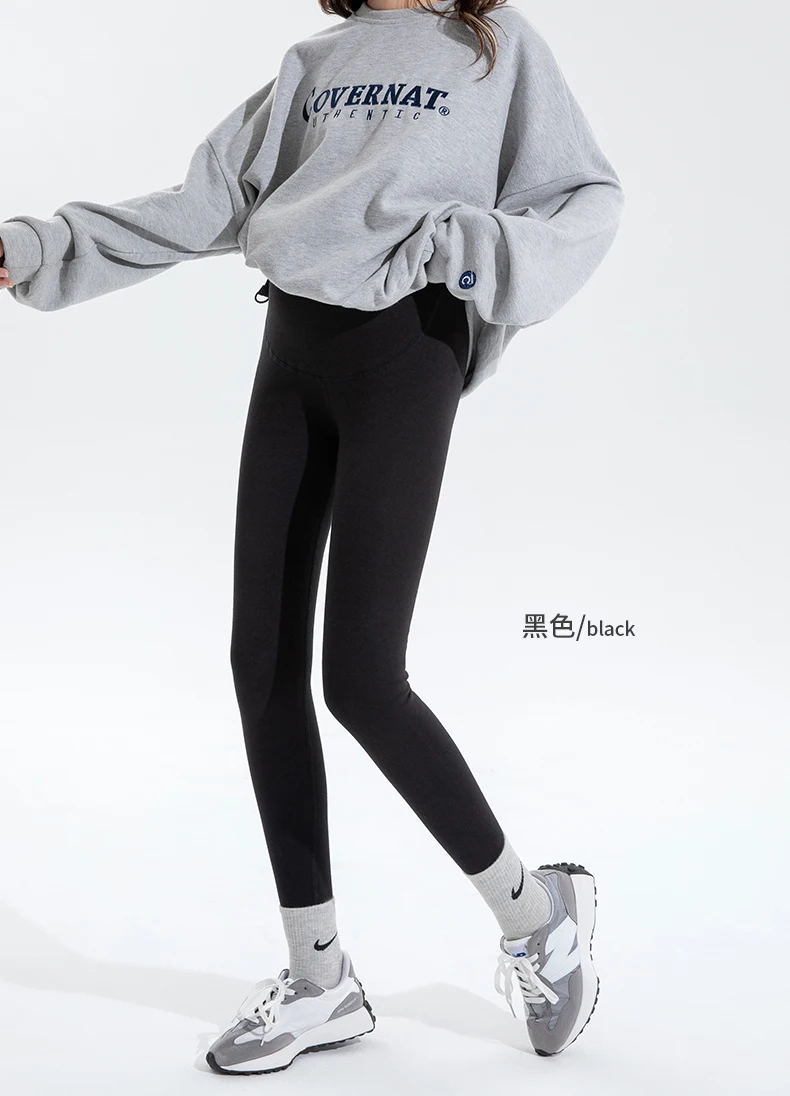 Una mujer con una sudadera gris y pantalones negros