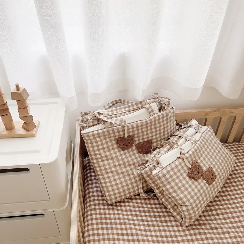 Una cama con dos almohadas y un juguete en la mesita de noche