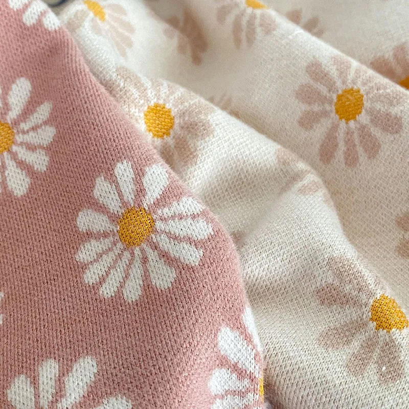 Una tela rosa y blanca con flores amarillas
