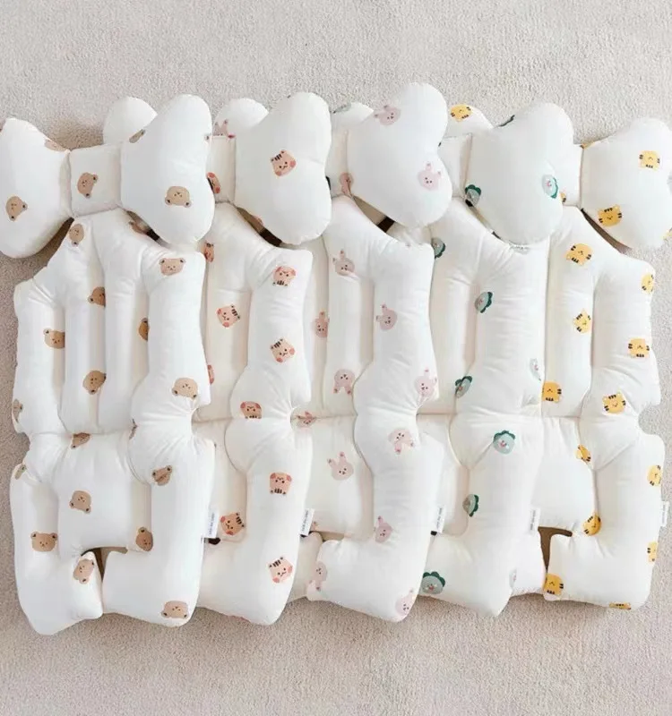 Un montón de pañales blancos para bebés con diseños amarillos y verdes