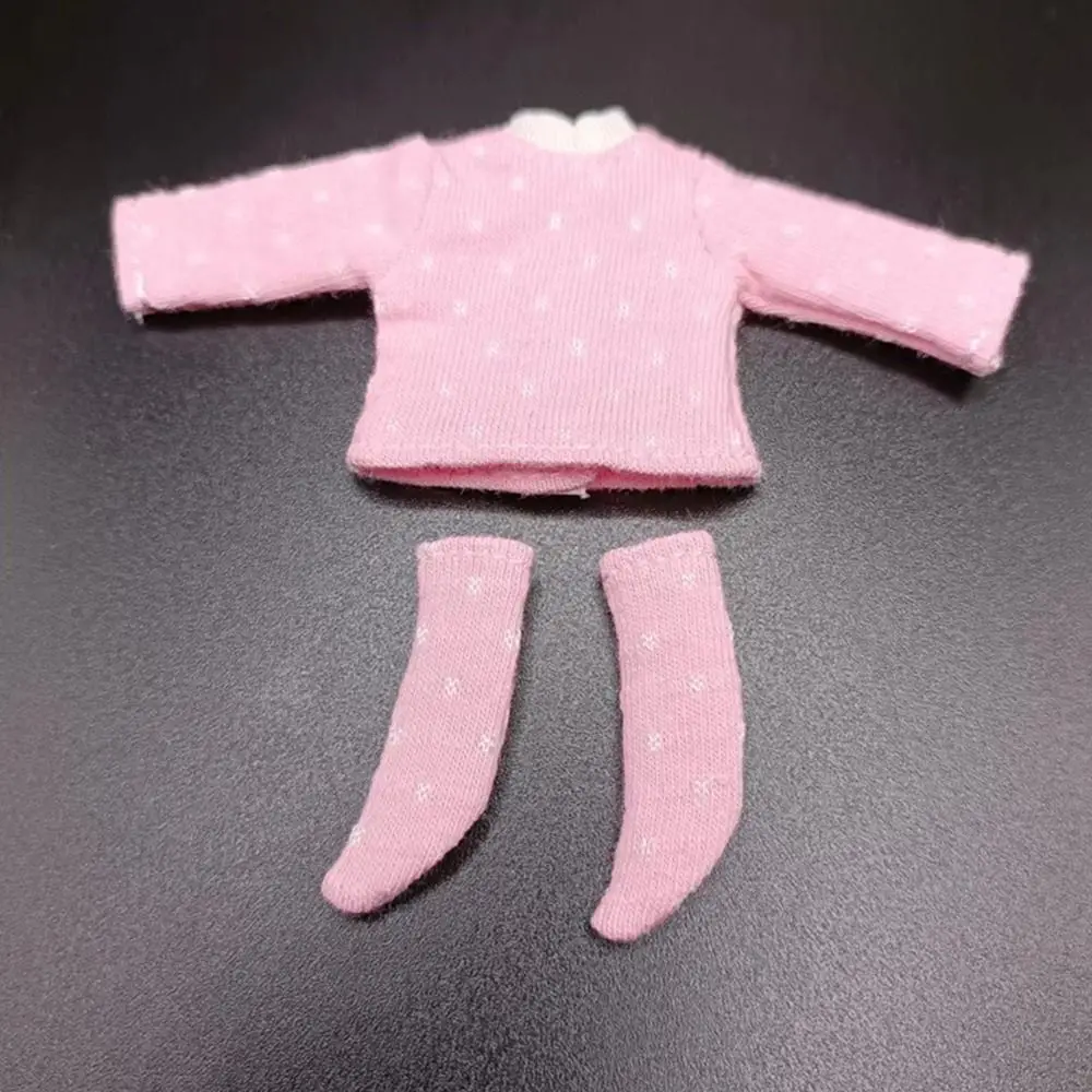 Un atuendo de muñeca rosa con un suéter y calcetines