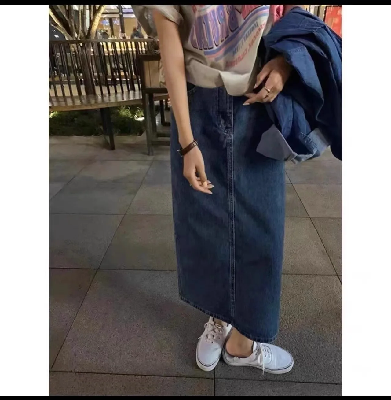 Una mujer con una falda azul y zapatos blancos