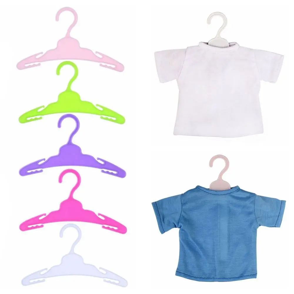 Una camisa blanca colgando de una percha al lado de una camisa azul