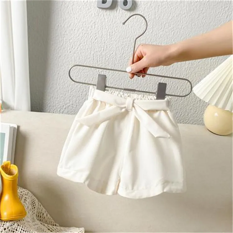 Detalle del lazo decorativo y cintura elástica en pantalones infantiles