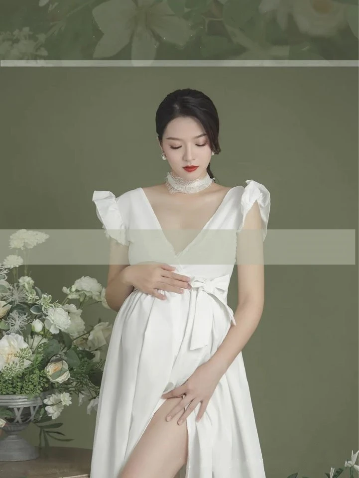 Detalle del vestido de maternidad blanco en sesión de fotos