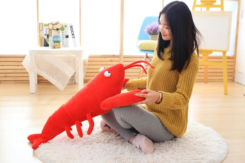 Langosta de peluche en posición decorativa sobre un sofá