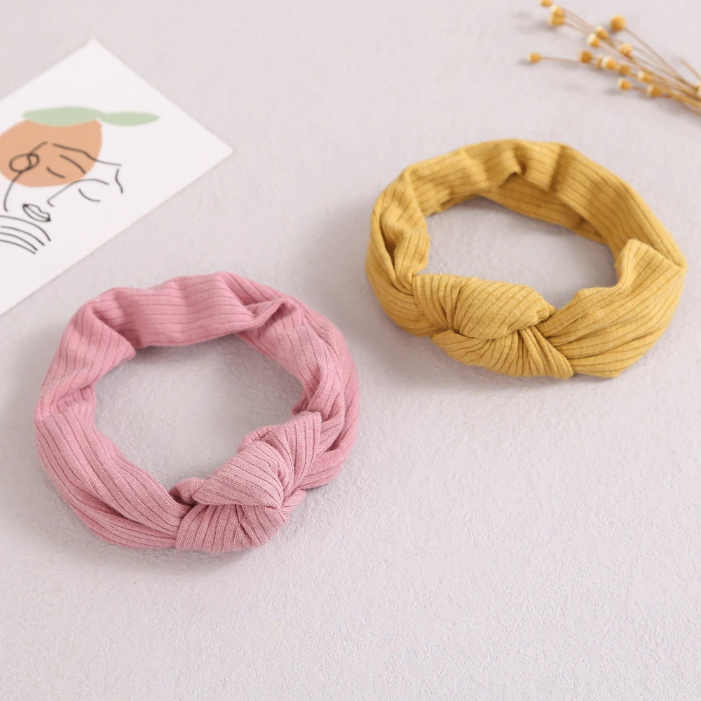Diadema de punto elástico con nudo torcido en color rosa