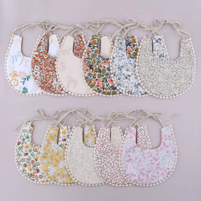 Pañuelo babero doble cara con borlas y estampado floral para bebé