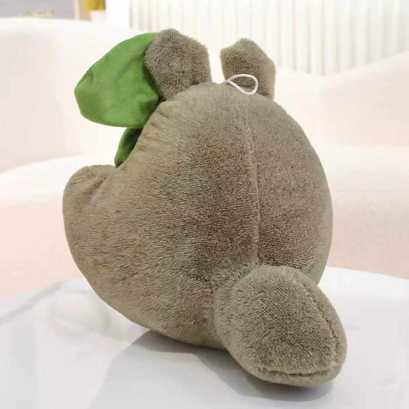 Muñeca Totoro sobre un sofá gris, mostrando su uso como almohada decorativa