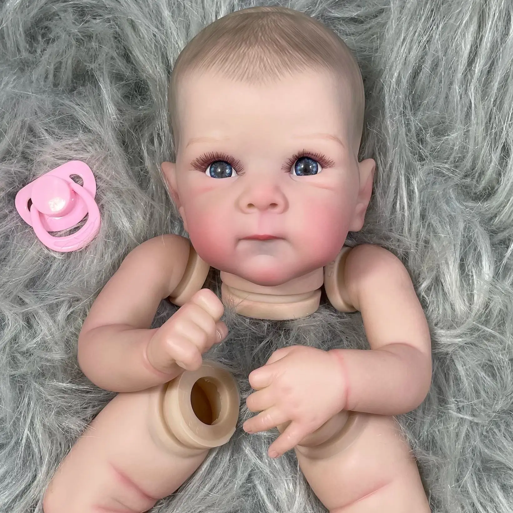 Muñeca vestida con ropa de bebé