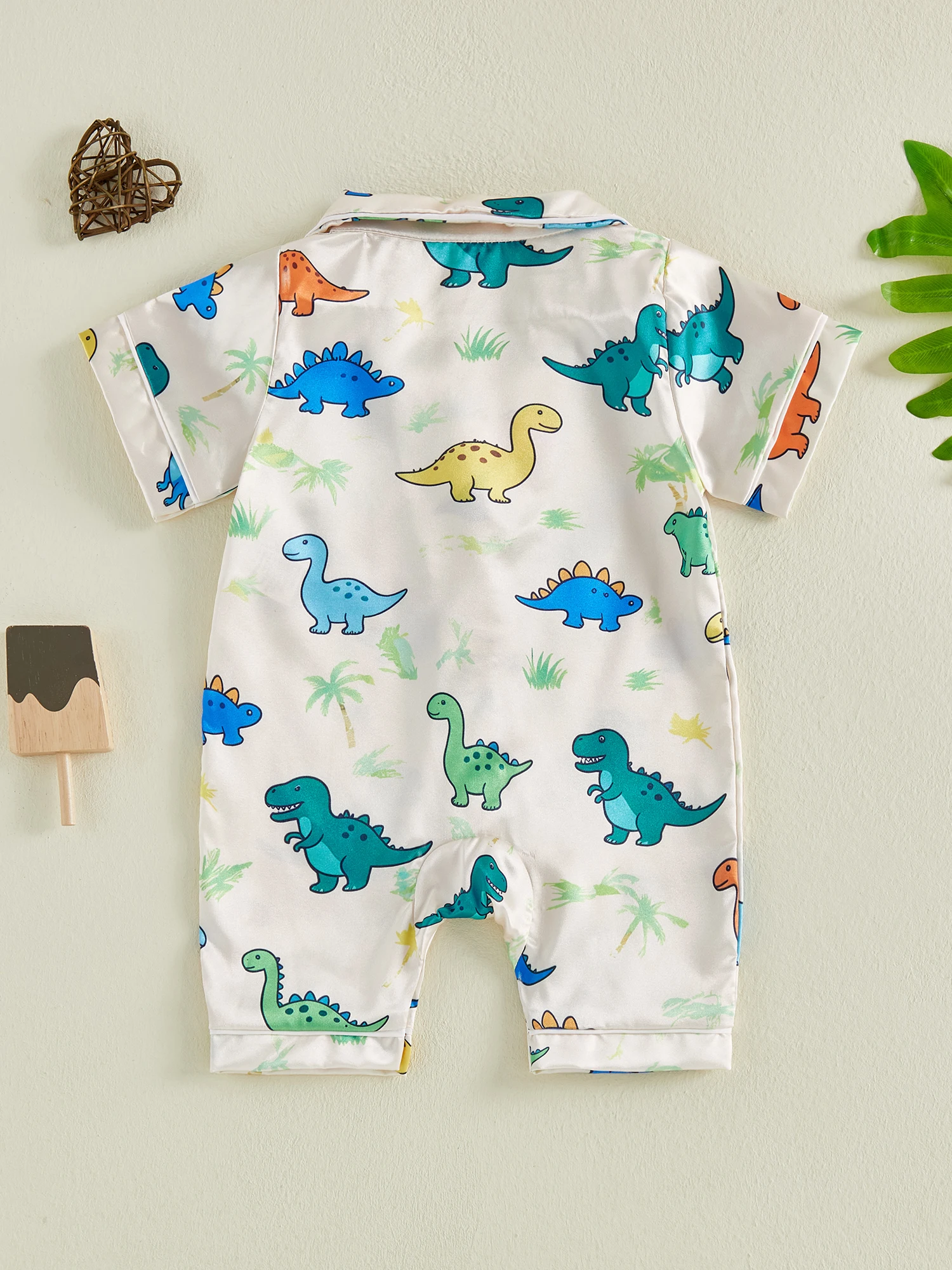 Vista del pijama de bebé con patrón dinosaurios/árboles