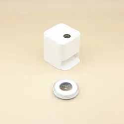 Casa de muñecas blanca con aspiradora robótica y microescena