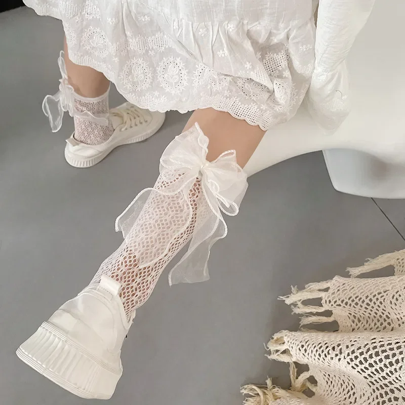 Detalle de lazo y rejilla de perlas en las medias