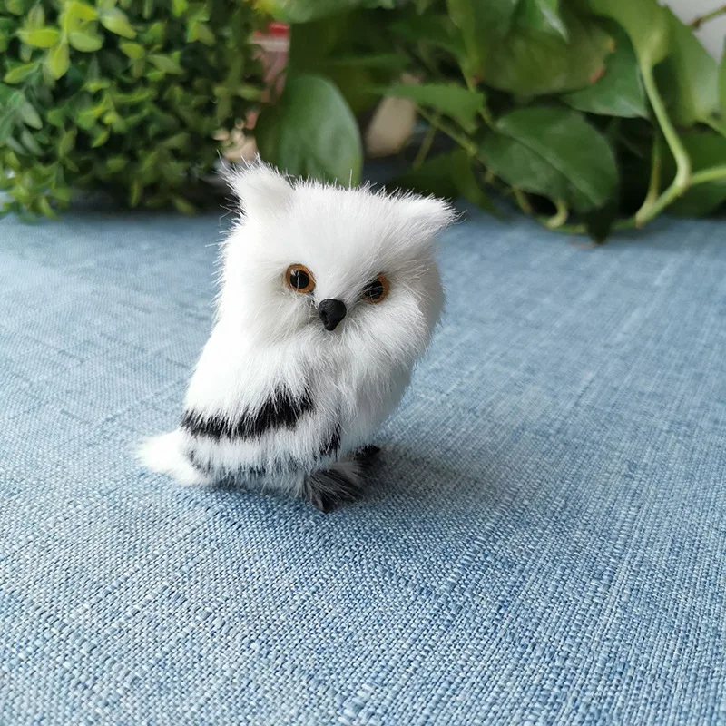 Búho de peluche blanco y negro en pose