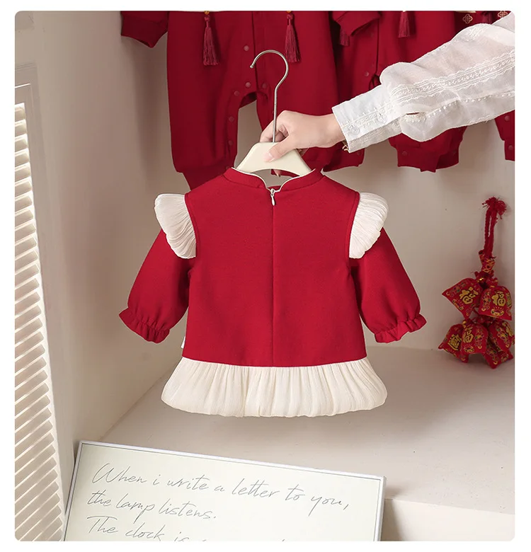 Detalle del bordado rojo y dorado en el vestido infantil