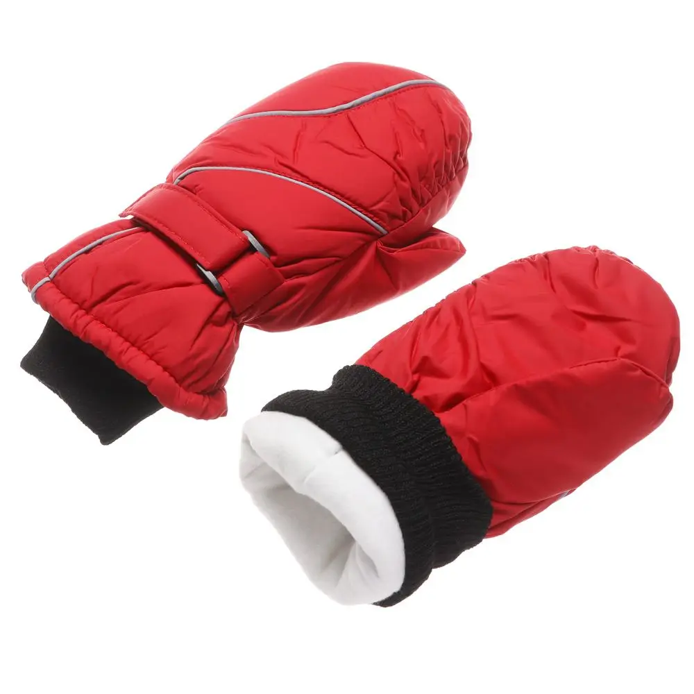 Niño usando los guantes mientras práctica esquí en pista nevada