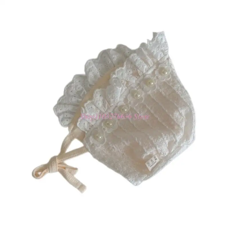 Gorro blanco de encaje para bebé sentado en superficie clara