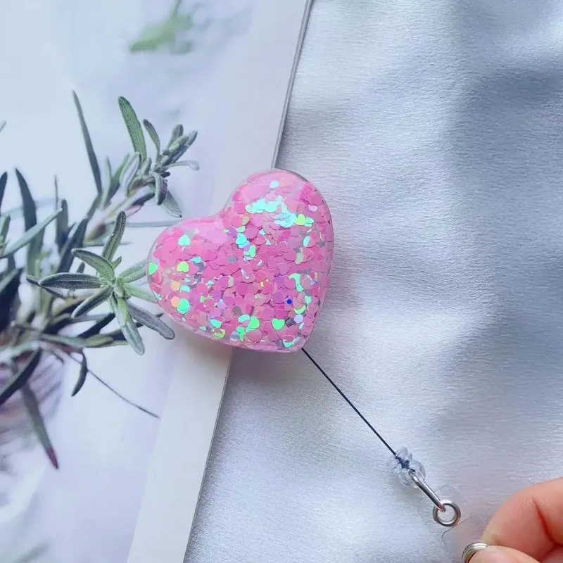 Portainsignias retráctil corazón con clip cocodrilo