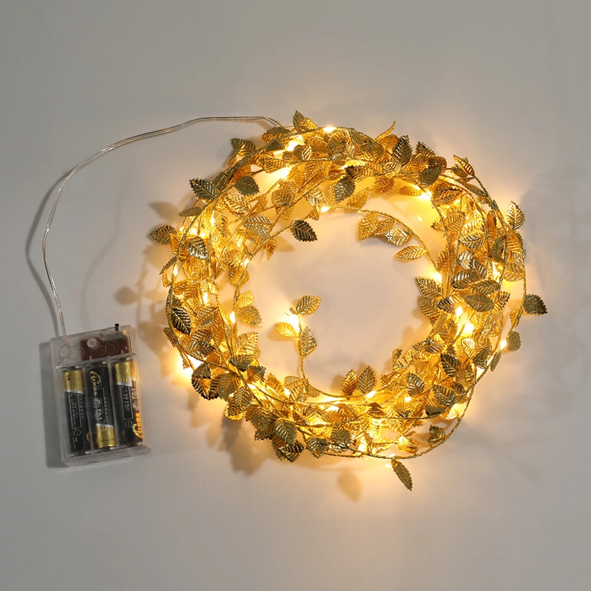 Guirnalda de luces de hojas doradas enrollada sobre una mesa de celebración