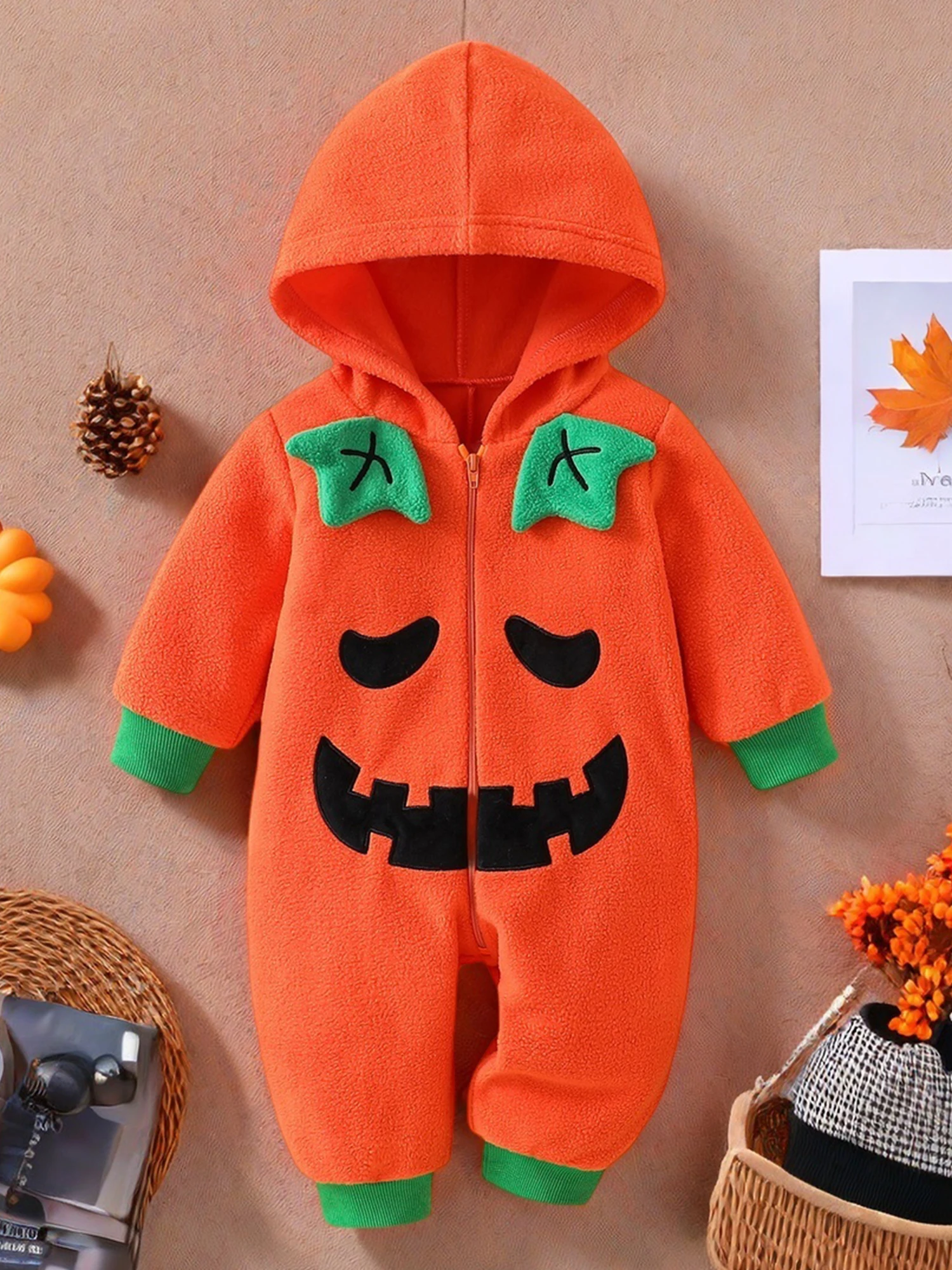 Bebé posando con el disfraz de calabaza Tregren en un entorno decorado para Halloween
