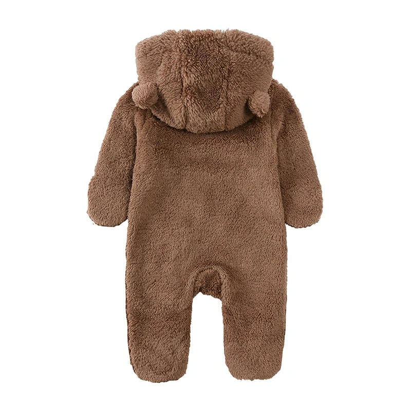 Bebé con mameluco de oso peludo saliendo al exterior