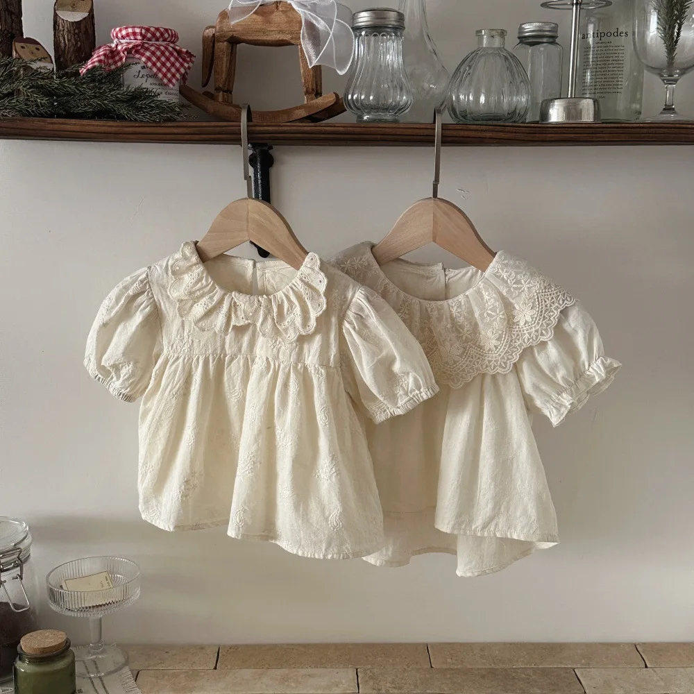 Blusa de algodón con encaje floral y cuello con volantes