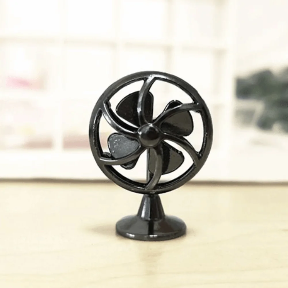 Ventilador en bronce sobre escritorio de muñecas con lámpara