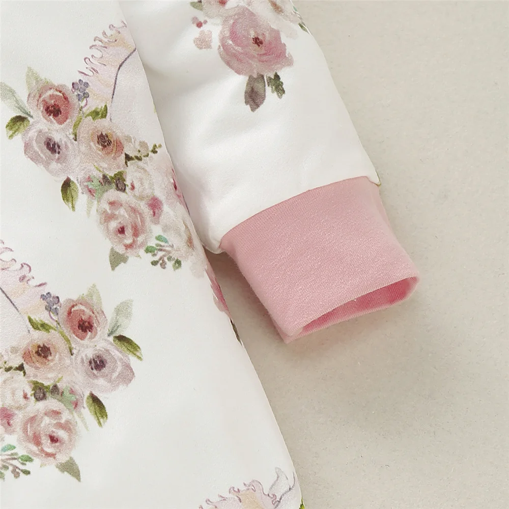 Modelo de bebé usando el pelele rosa de manga larga