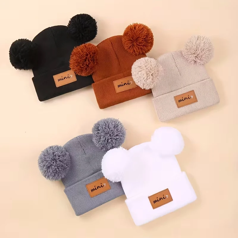 Gorro tejido para bebé con pompón en color beige